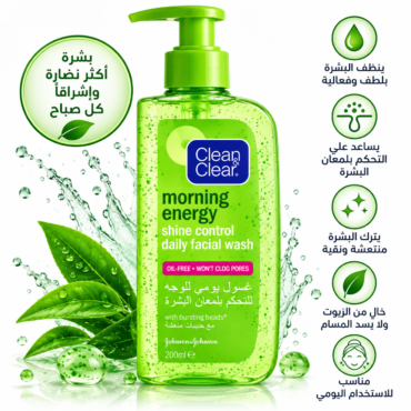 Green bottle of Clean & Clear Morning Energy daily facial wash with pump, surrounded by water splashes and green leaves.