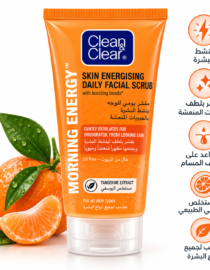 Orange Clean & Clear Morning EnergY Daily Facial Scrub tube with bursting beads and tangerine extract, placed beside oranges and leaves.