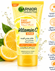 file_00000000ff18820a8e7bab69ee42aa00 - المول الشامل في الاردن Garnier SkinActive Vitamin C Scrub tube surrounded by lemon slices and splashes, orange and white packaging with Arabic text on the label and side icons on the right.