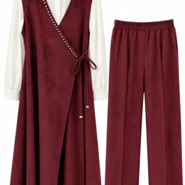Burgundy wrap dress with pearl trim tied at the waist, worn over a white blouse, paired with matching burgundy wide-leg pants.