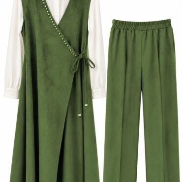 Green wrap-style sleeveless vest over a white long-sleeve shirt with wide cuffs, paired with matching green wide-leg trousers; front wrap ties at the waist, decorative studs along the wrap edge.