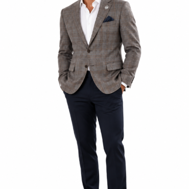Man in a gray plaid blazer with white dress shirt, navy trousers, and black dress shoes, hands in pockets, accessorized with a blue pocket square and lapel pin.