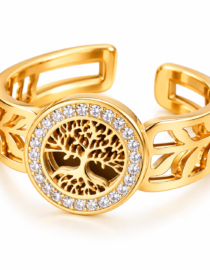Gold cuff bracelet with an open filigree leaf pattern and a circular tree of life centerpiece outlined by a ring of clear stones