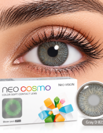 Close up of an eye with a gray contact lens Neo Cosmo color soft contact lenses box visible beside a single lens Gray D 825