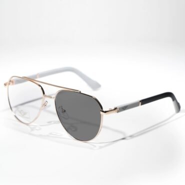 Close-up of rose-gold metal sunglasses with dark lenses resting on a white surface, fashion accessory image.