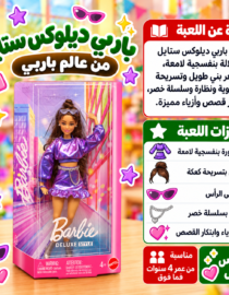 دمية باربي من مجموعة Deluxe Style داخل صندوق وردي شفاف مع فستان بنفسجي وأكسسوارات ملونة أمام خلفية متجر ألعاب